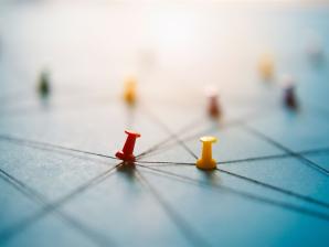 Bunte Stecknadeln mit Fäden, die ein Netzwerk auf einer Karte darstellen