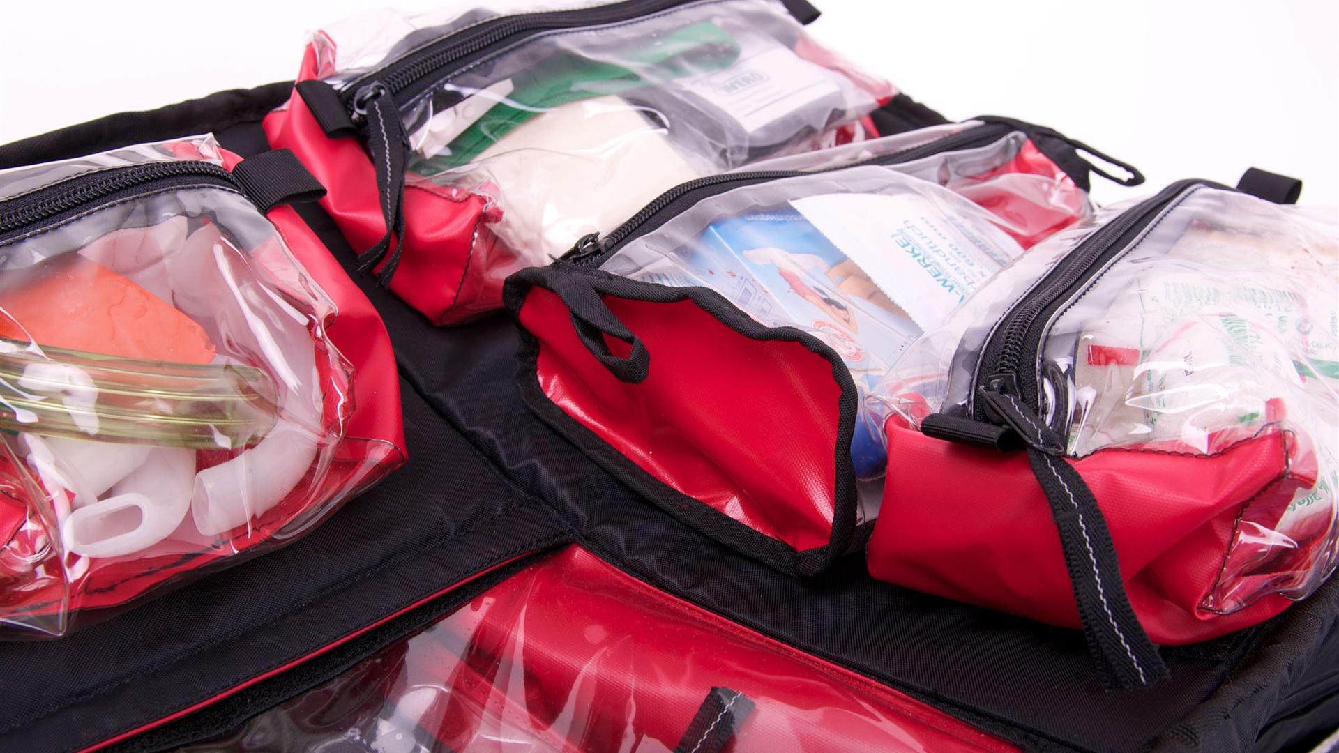 Geöffnetes Erste-Hilfe-Set mit durchsichtigen Taschen und medizinischem Inhalt