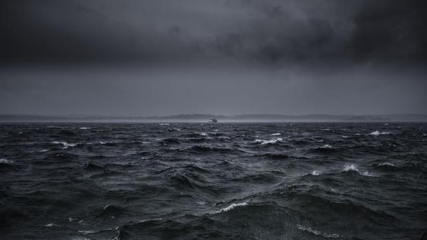 Stürmische See mit hohen Wellen und einem Schiff am Horizont bei bewölktem Himmel