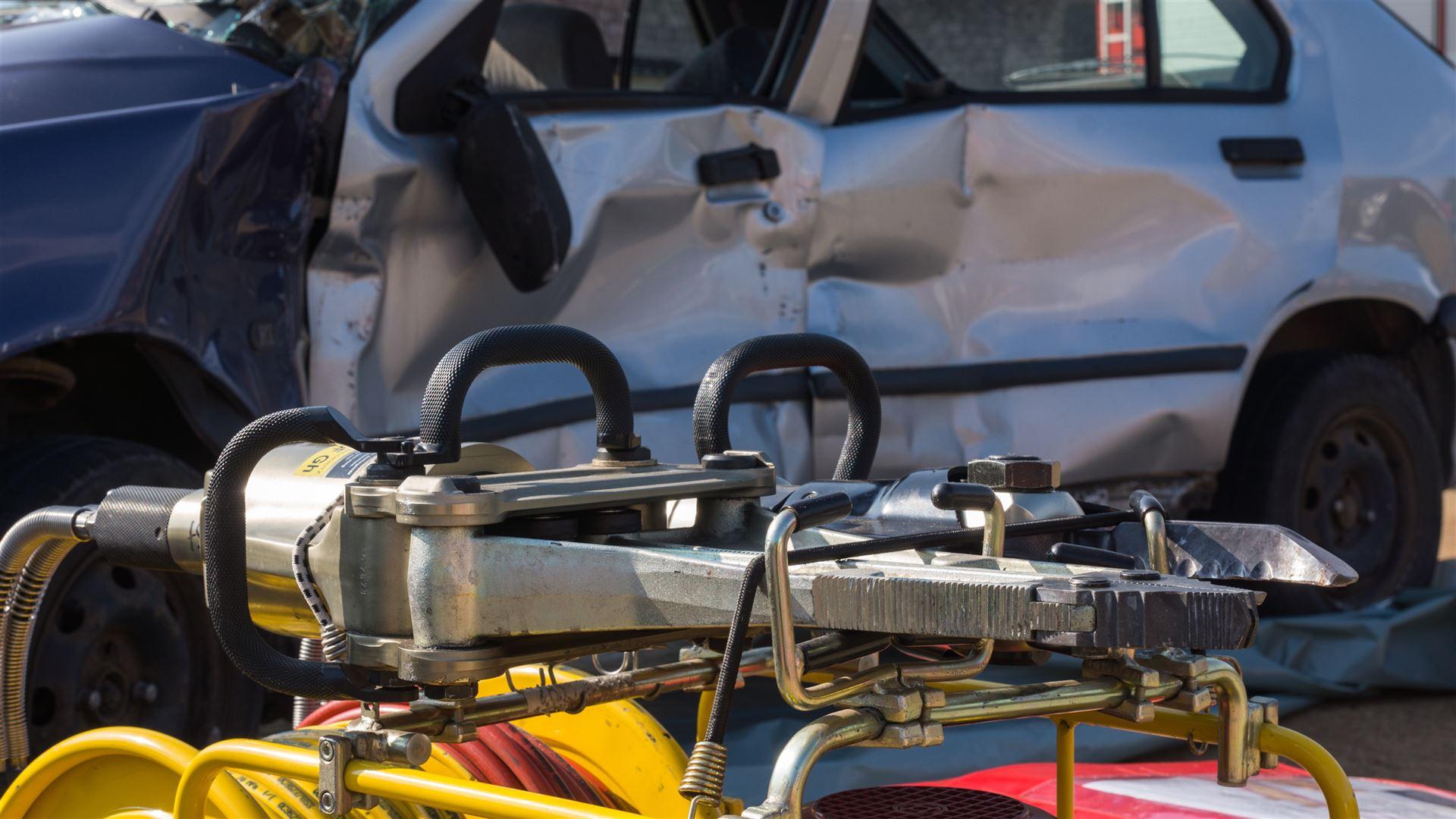 Hydraulisches Rettungsgerät vor einem verformten Unfallfahrzeug